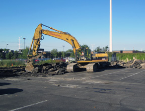 Backhoe removing the parking lot